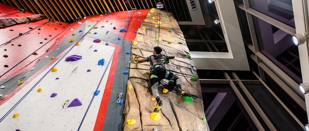 student climbing the rock wall
